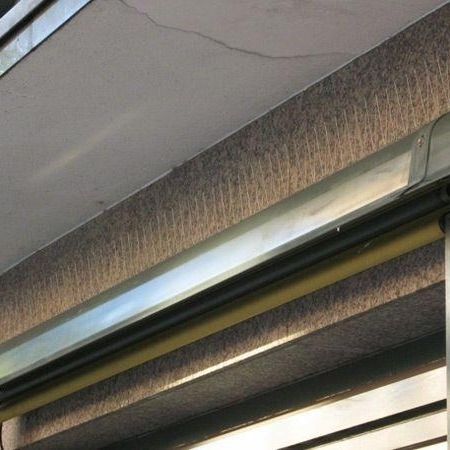 Taubenabwehr über einer Markise an einer Hauswand