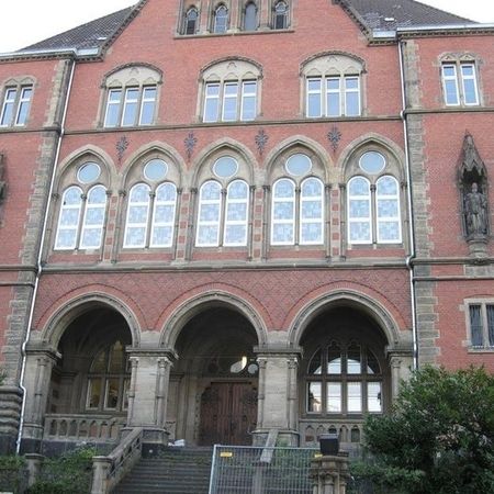 Ein altes rotes Gebäude mit großen Fenstern