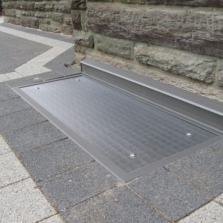 Lichtschacht - Abdeckung nach Maß auf einem gepflasterten Boden